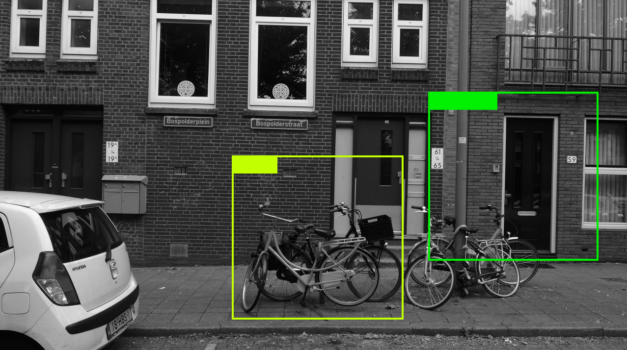 Photo of a house fasade with bicycles and machine learning tracking marks around selected objects